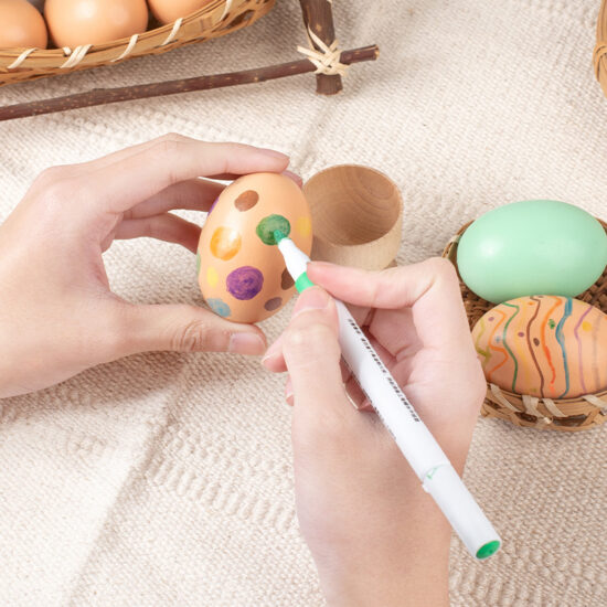 Children painting wooden Easter eggs for DIY holiday craft activity